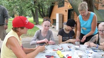 Group of campers participating in a beading activity 