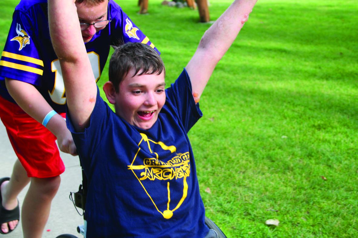 Camper in a wheelchair with a victory salute.