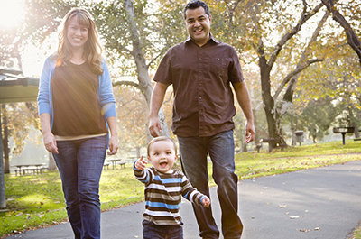 Family of three strolling through the park