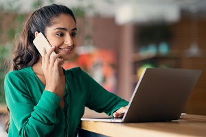 woman at laptop and on phone
