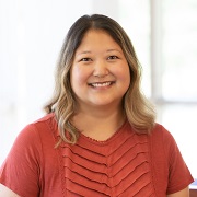 A person of Asian descent smiling at camera