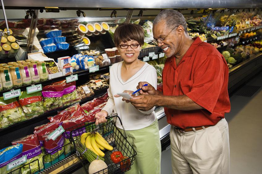 Couple look over grocery list in produce section of store