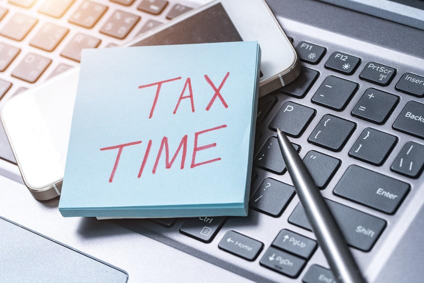 Post it note on calculator that says "Tax Time"