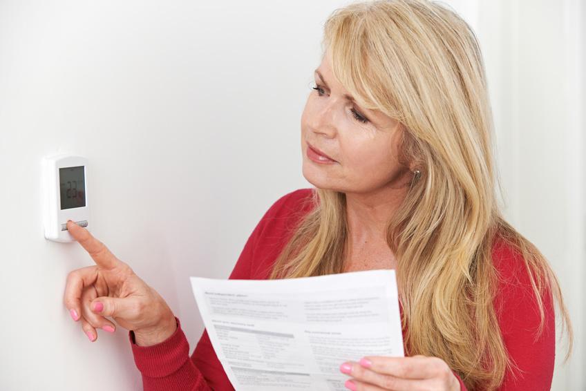 Woman adjusting thermostat