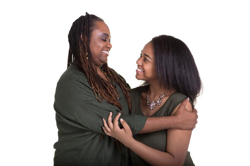 Mother and daughter smiling and hugging each other