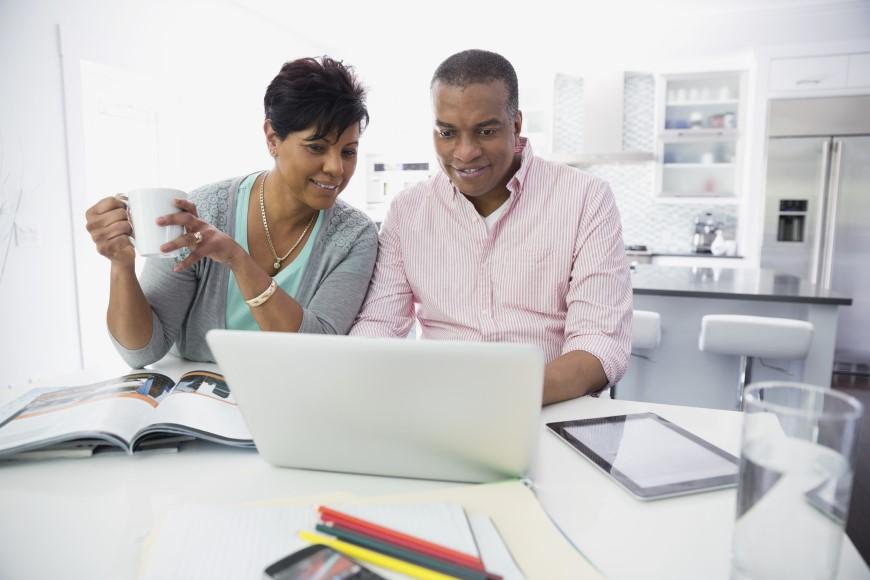 Middle-ages African American couple working at laptop