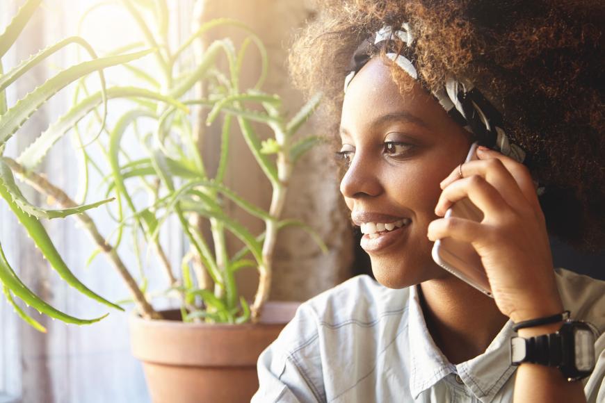 student of color on phone