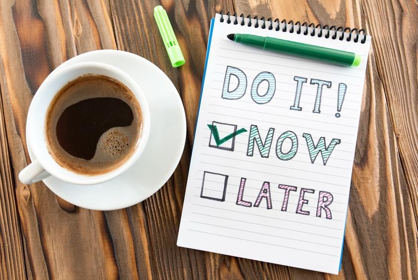 Note pad next to cup of coffee. Written on note pad: Do It! Now or Later. The word Now is checked