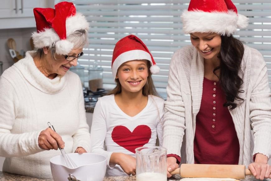 Older woman, young woman, and child baking together in kitchen