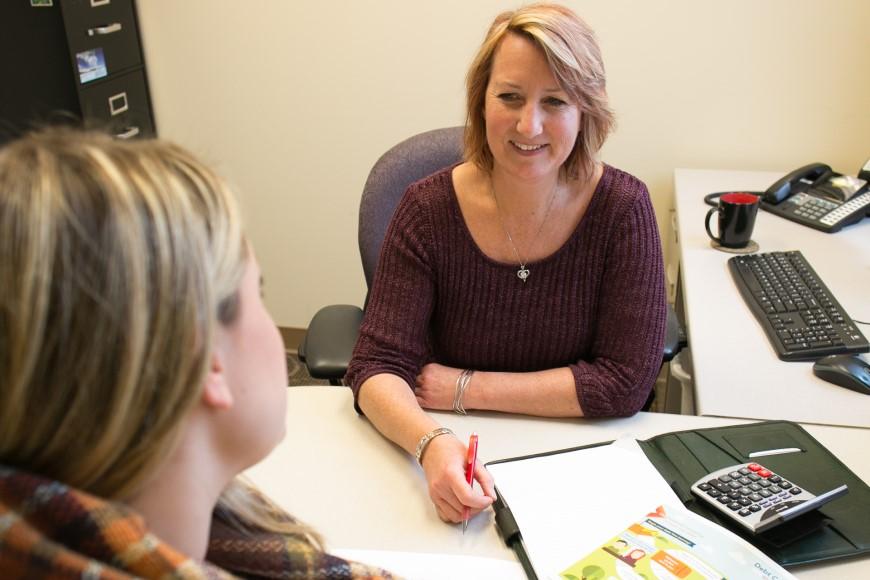Woman talking with and presenting info to another about finances