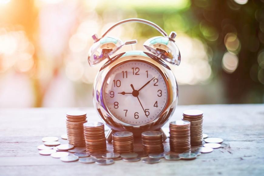 time clock with money around it
