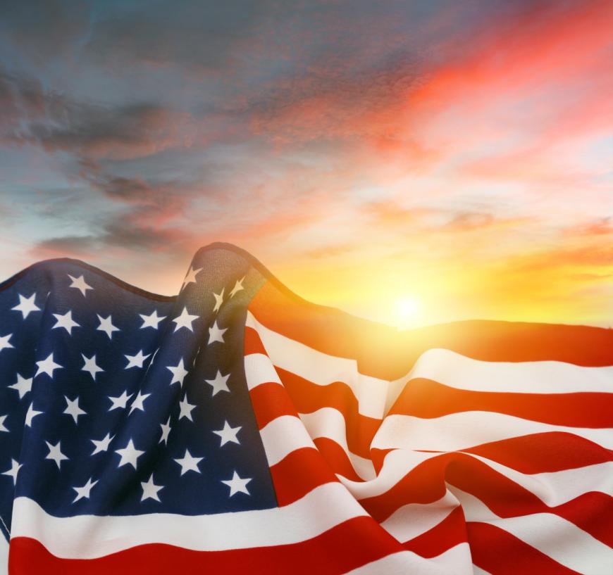 U.S flag with multicolored sky in the background