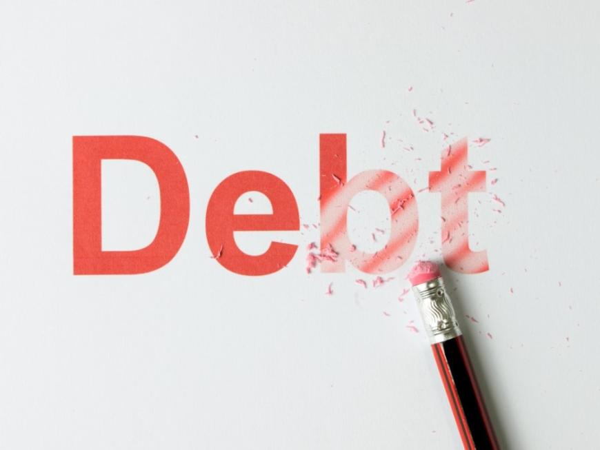 An eraser wiping out the word "Debt," which is in red type.