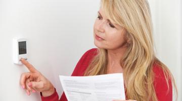 Woman adjusting thermostat