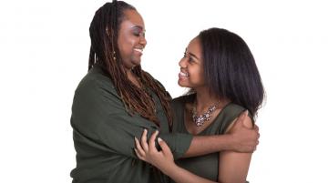 Mother and daughter smiling and hugging each other