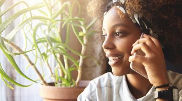 student of color on phone