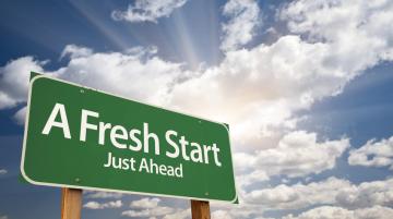 Green road sign with words A Fresh Start Just Ahead painted in white