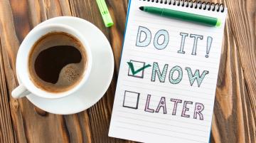 Note pad next to cup of coffee.  Written on note pad:  Do It!  Now or Later.  The word Now is checked