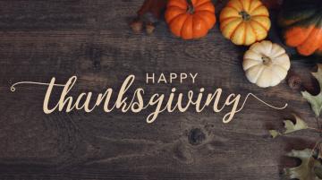 Happy Thanksgiving text overlaid on brown background with pumpkins