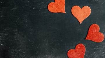 Four red heart shapes on black background