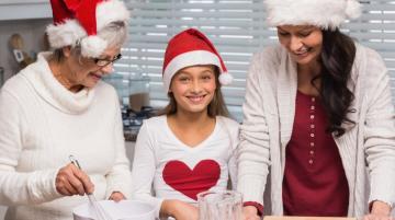 Older woman, young woman, and child baking together in kitchen