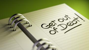 Open spiral notebook with words "{Get out of debt" written on right page