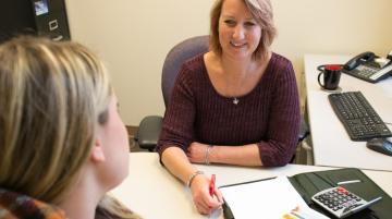 Woman talking with and presenting info to another about finances