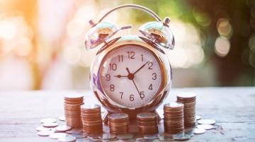 time clock with money around it