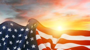U.S flag with multicolored sky in the background