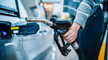 Woman pumping gas into her auto