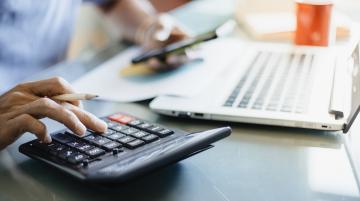 person typing on calculator