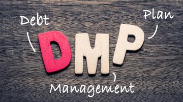 Letters DMP overlaid on a wooden surface.  Next to the “D” is the word Debt, next to the “M” is the word Management, and next to the “P” is the word Plan.
