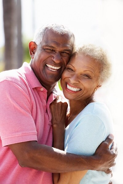 Couple embracing outside on a sunny day.