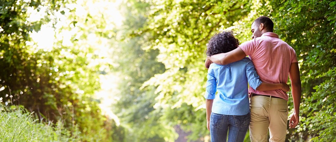 couple embracing walking down a path.