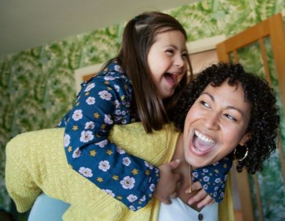 Mother giving her daughter a piggyback ride.
