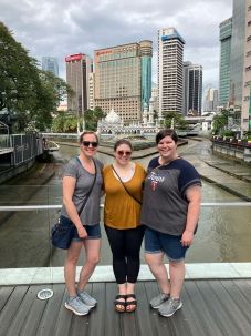 Trisha (center) with two friends on a trip to Malaysia.