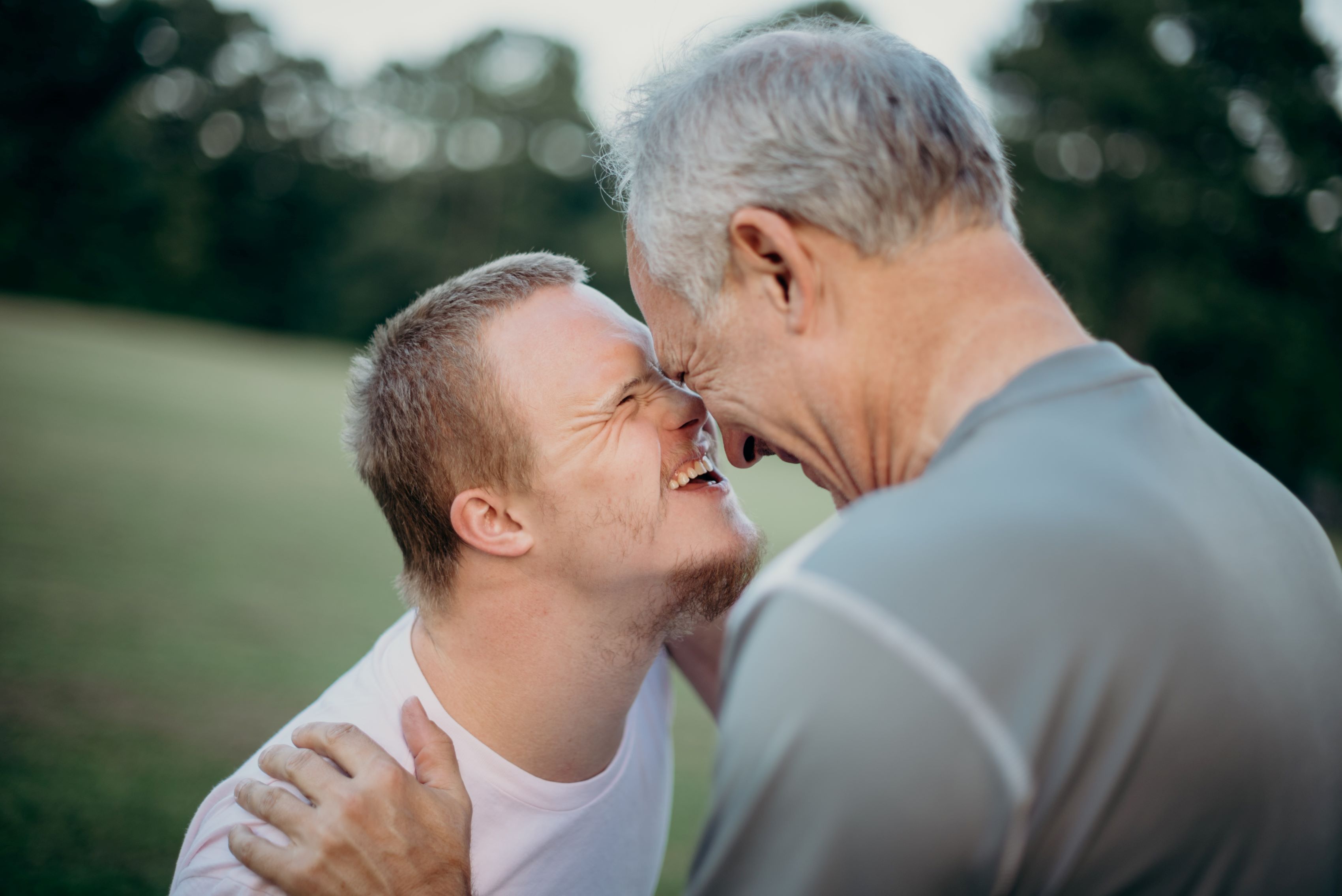 Two people touching heads and smiling at one another