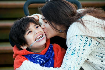 CSG Woman kissing boy in wheelchair