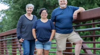 From left to right: Janet, Rosa and Ron pose for a picture on a bridge.